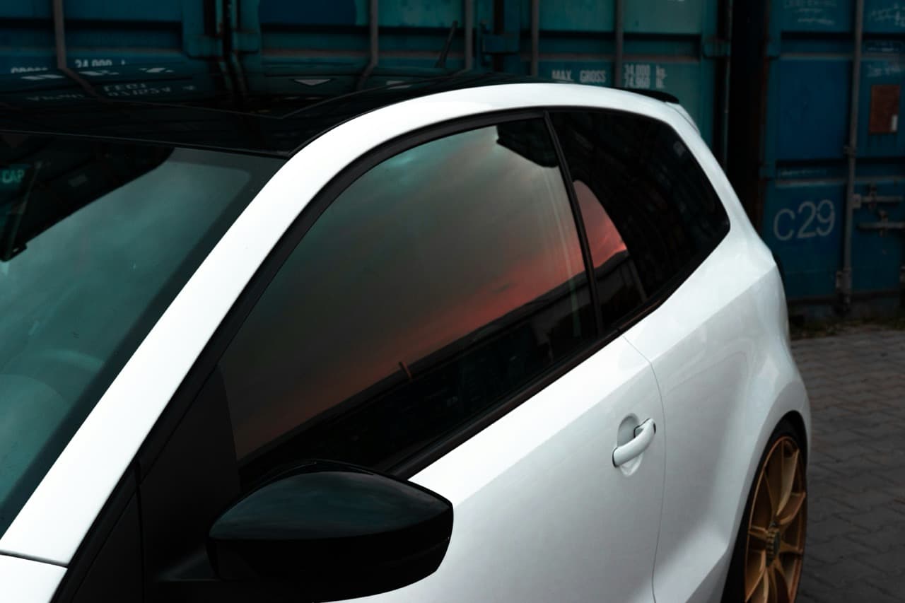 Professional window tinting installation on a car windshield in Miami
