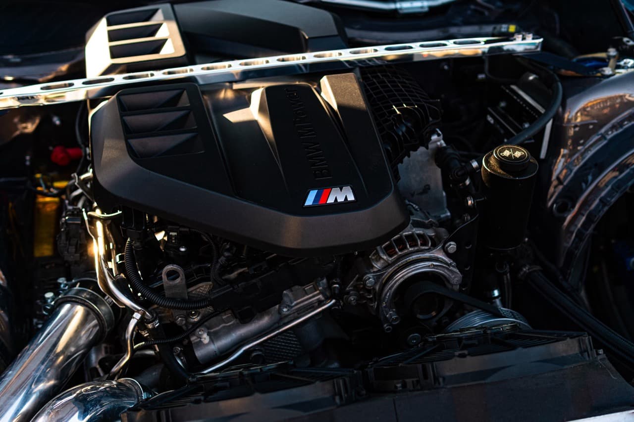 Technician inspecting the engine bay and cooling system of a European luxury car at DS Proformance Miami