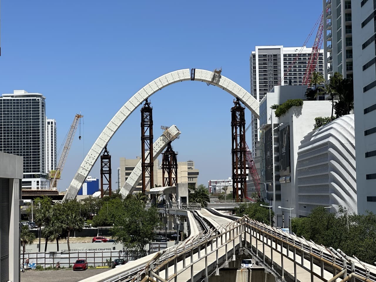 Construcción de puente en Miami con grúas y rascacielos al fondo